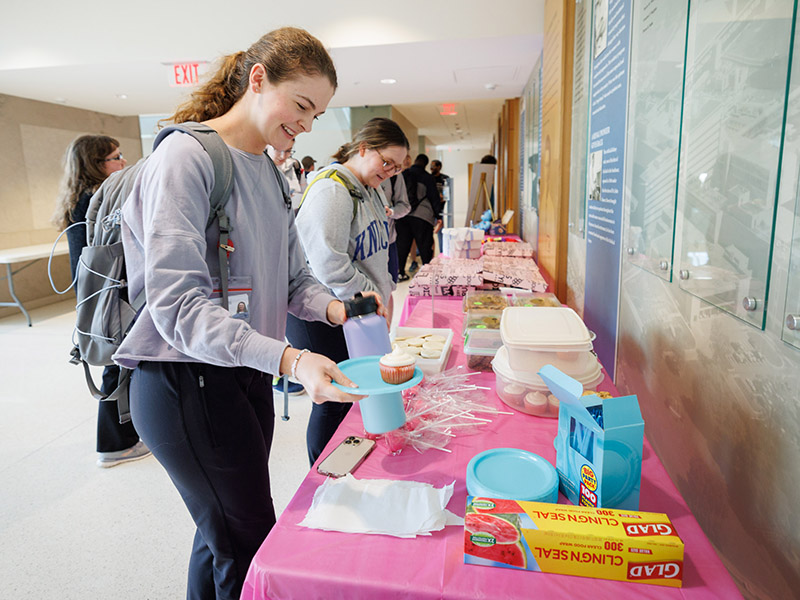Medical Student Sanders Goode eyes a decadent cupcake, one of the treats offered during the bake sale portion of Rare Disease Day.